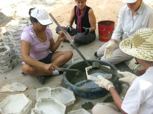 Pouring a layer of cement mixture into the moulds.